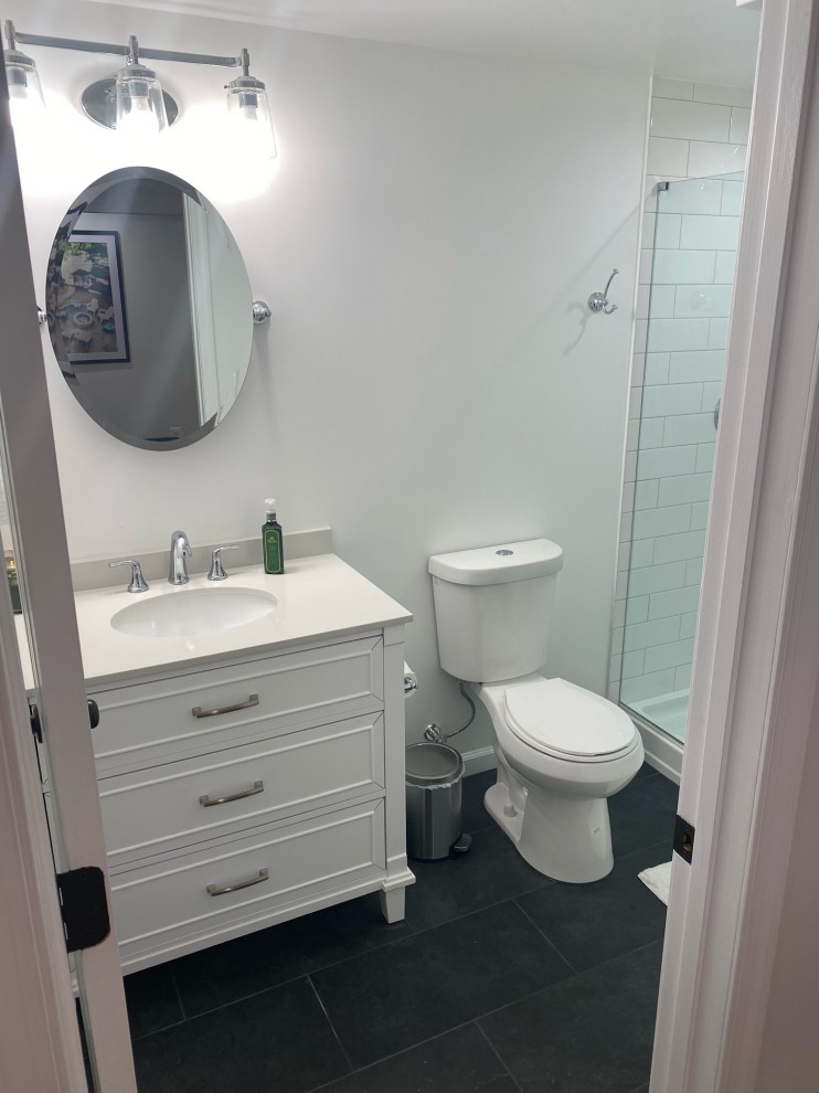 Photo of a transitional bathroom in Other with white cabinets, white walls, slate floors, black floor, a hinged shower door, a shower seat and a single vanity.