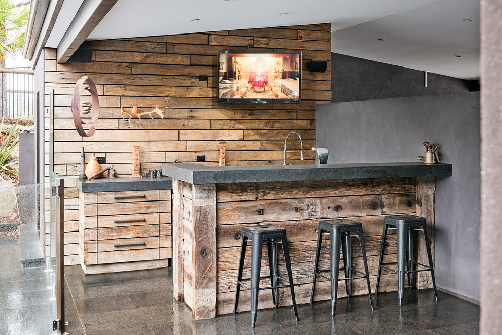This is an example of a country galley seated home bar in Melbourne with flat-panel cabinets and distressed cabinets.