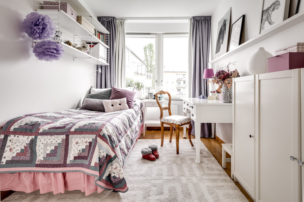 Design ideas for a transitional kids' room for girls in Stockholm with white walls, medium hardwood floors and brown floor.
