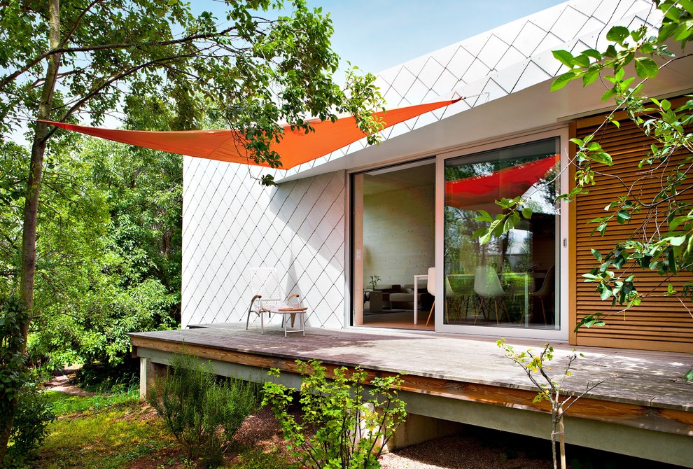 This is an example of a mid-sized contemporary backyard deck in Cologne with an awning.