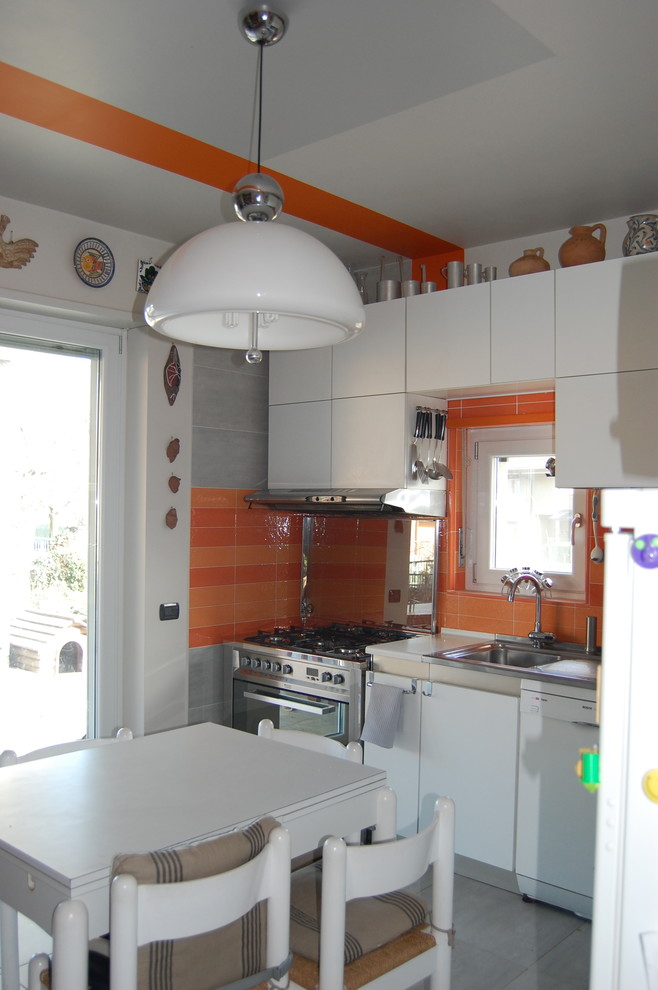 This is an example of a mid-sized contemporary l-shaped eat-in kitchen in Turin with a single-bowl sink, flat-panel cabinets, white cabinets, laminate benchtops, stainless steel appliances, porcelain floors, grey floor and white benchtop.