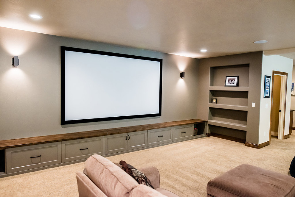 Photo of a large traditional enclosed home theatre in Boise with grey walls, carpet, a projector screen and beige floor.