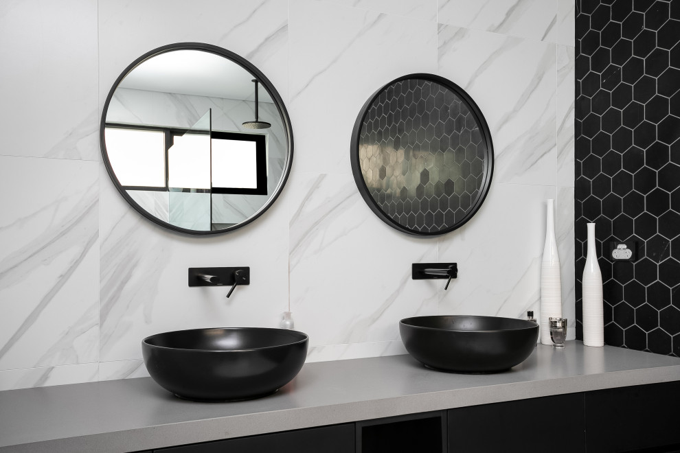 Photo of a mid-sized contemporary master bathroom in Sydney with black cabinets, a two-piece toilet, black and white tile, marble, ceramic floors, a pedestal sink, engineered quartz benchtops, black floor and grey benchtops.