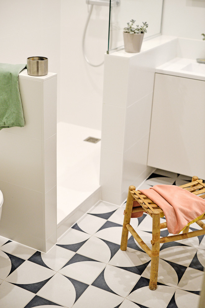 Design ideas for a small modern 3/4 bathroom in Strasbourg with white cabinets, a curbless shower, a wall-mount toilet, white tile, ceramic tile, white walls, cement tiles, a console sink, an open shower and white benchtops.
