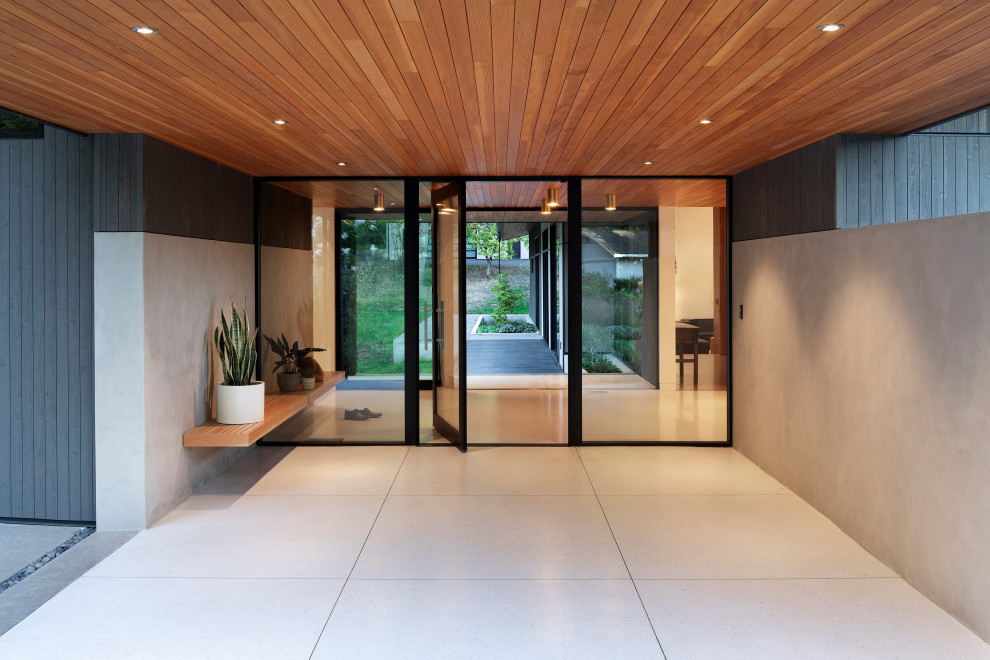 Design ideas for a large midcentury foyer in Portland with white walls, terrazzo floors, a pivot front door, a glass front door, white floor and wood.