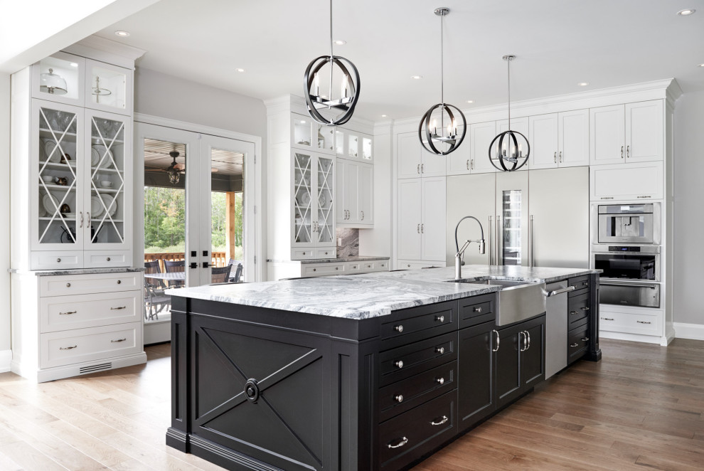 Example of a huge transitional light wood floor and brown floor eat-in kitchen design in Toronto with a farmhouse sink, shaker cabinets, white cabinets, granite countertops, gray backsplash, granite backsplash, stainless steel appliances, an island and gray countertops