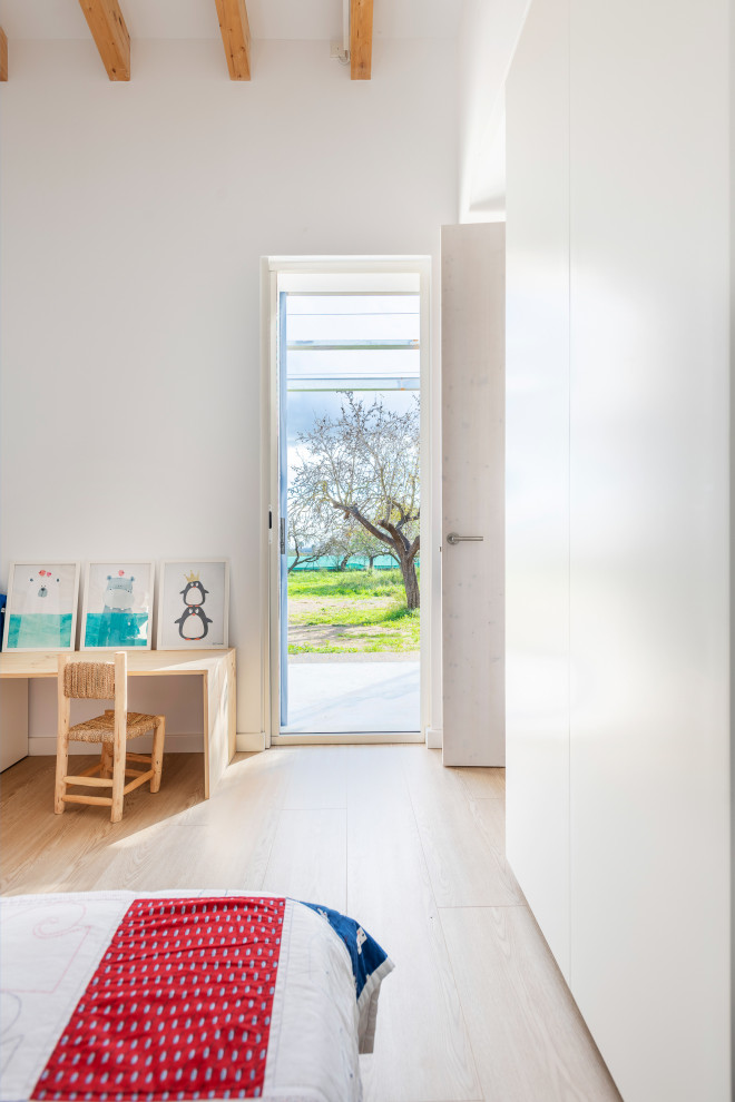 Ejemplo de dormitorio infantil de 4 a 10 años mediterráneo pequeño con paredes blancas, suelo laminado, suelo marrón y vigas vistas