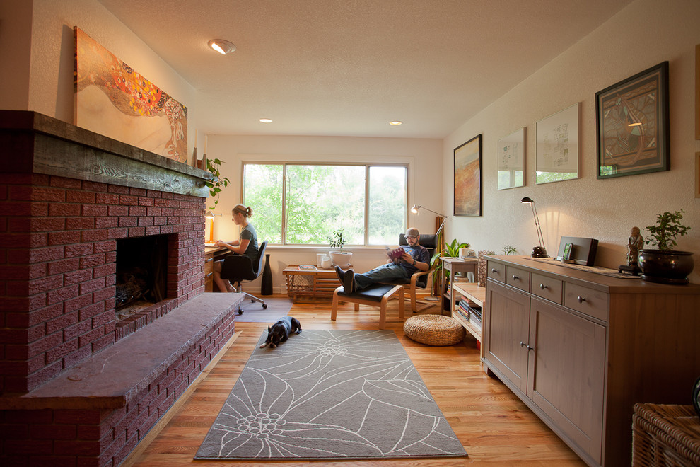 This is an example of a transitional family room in Denver with a brick fireplace surround.