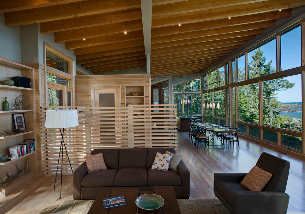 This is an example of a small country open concept family room in Seattle with grey walls and light hardwood floors.