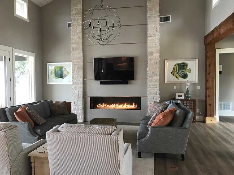 Inspiration for an expansive contemporary open concept family room in Dallas with grey walls, laminate floors, a ribbon fireplace, a tile fireplace surround and a wall-mounted tv.