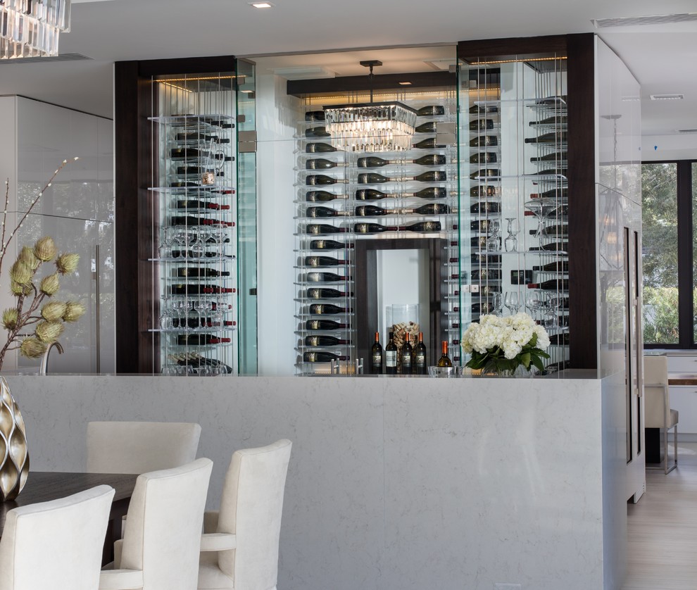 This is an example of a mid-sized contemporary wine cellar in Orlando with light hardwood floors and display racks.