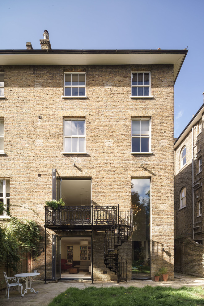 Design ideas for a traditional three-storey brick beige exterior in London with a flat roof.