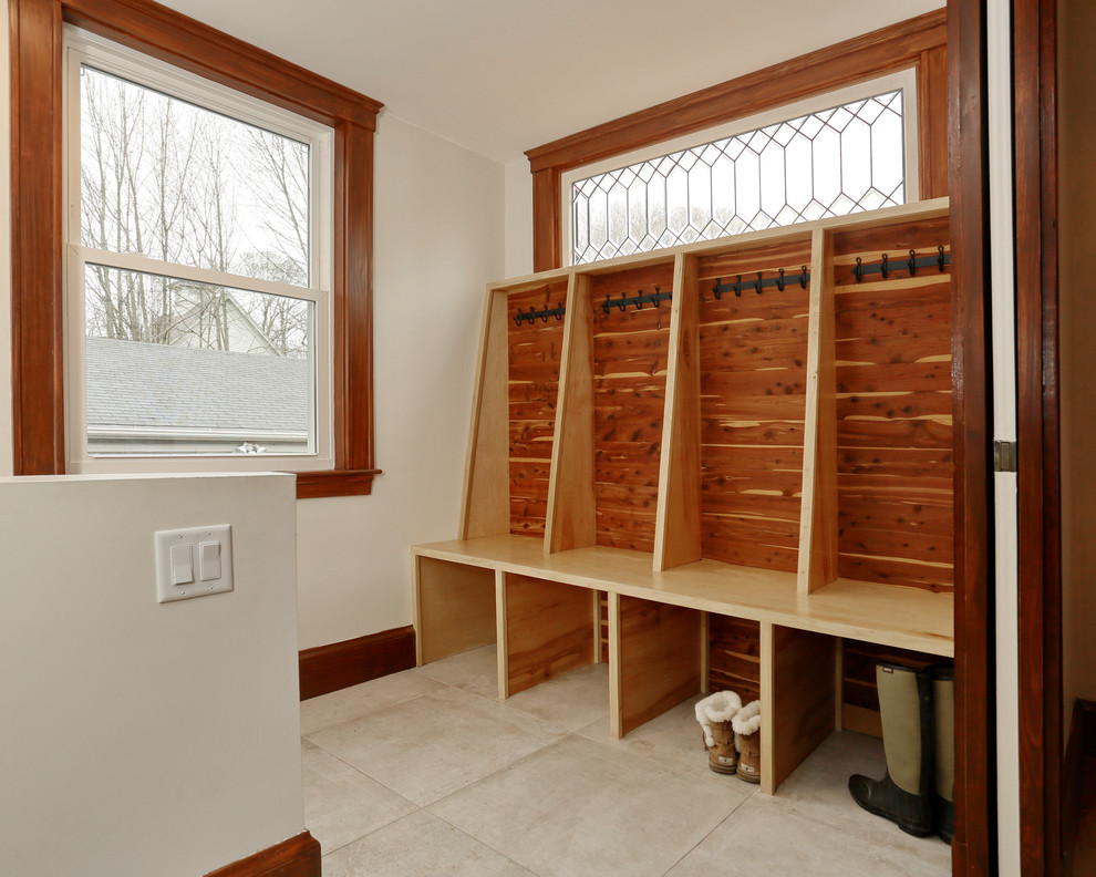 Photo of a small transitional mudroom in Boston with white walls and porcelain floors.
