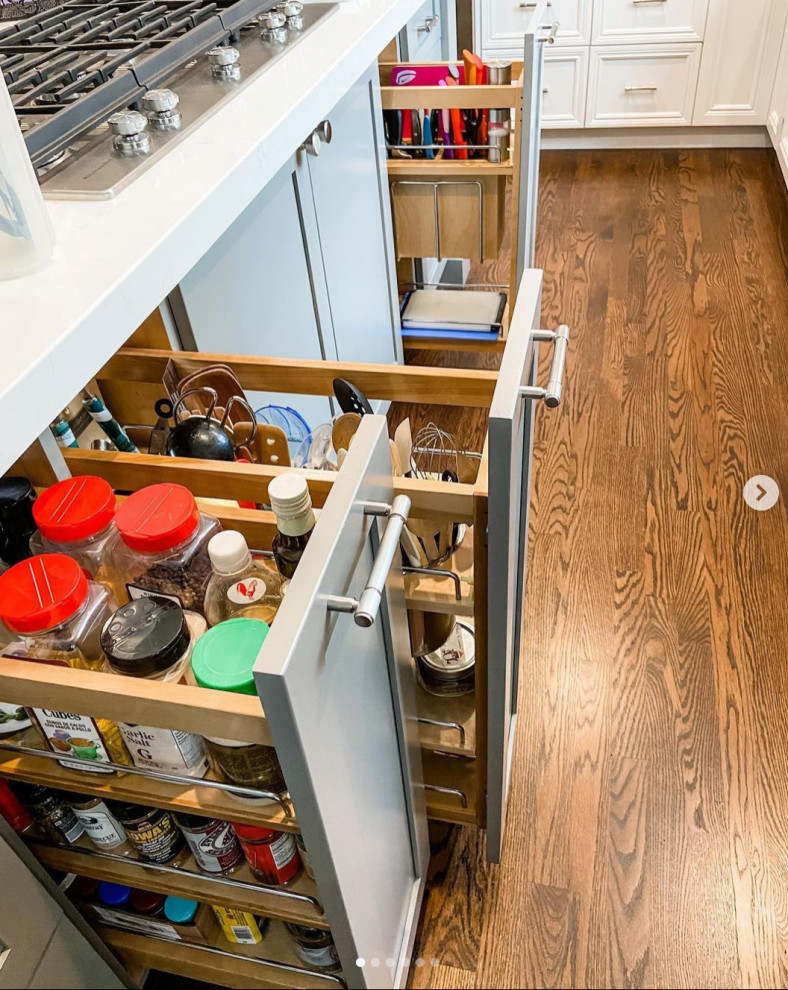 Mittelgroße Moderne Wohnküche in L-Form mit Schrankfronten im Shaker-Stil, weißen Schränken, Marmor-Arbeitsplatte, Küchengeräten aus Edelstahl, braunem Holzboden, Kücheninsel, braunem Boden und weißer Arbeitsplatte in Seattle