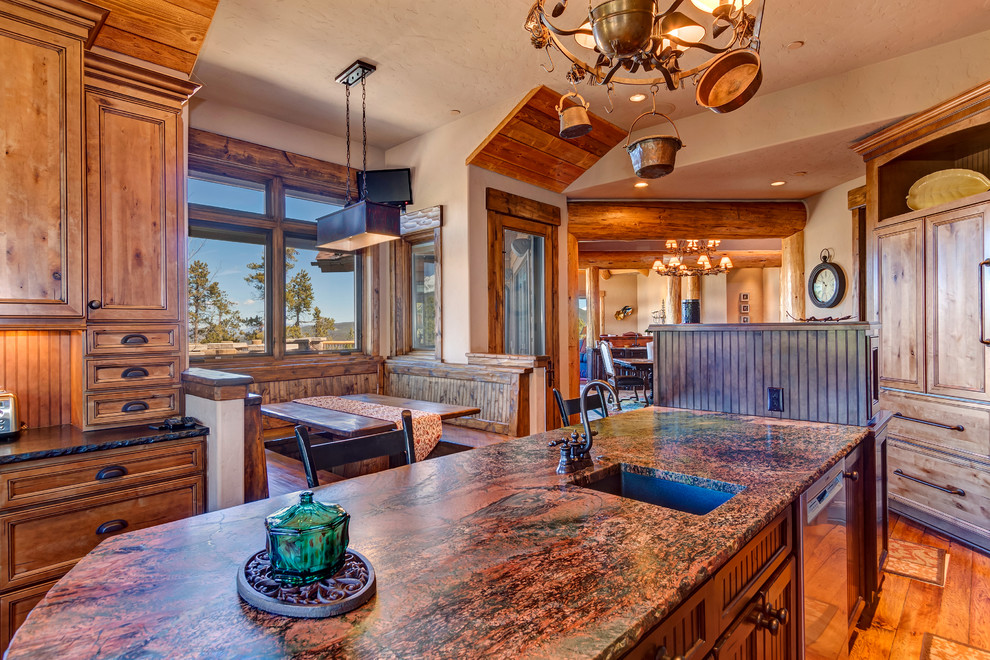 Large mountain style u-shaped medium tone wood floor and brown floor eat-in kitchen photo with louvered cabinets, distressed cabinets, granite countertops, beige backsplash, stone tile backsplash, stainless steel appliances, an island and red countertops