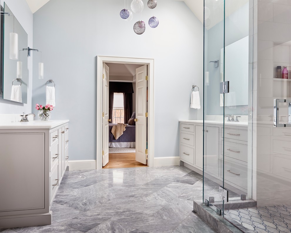 This is an example of a transitional master bathroom in Charlotte with flat-panel cabinets, white cabinets, a corner shower, blue walls, an undermount sink, grey floor and a hinged shower door.