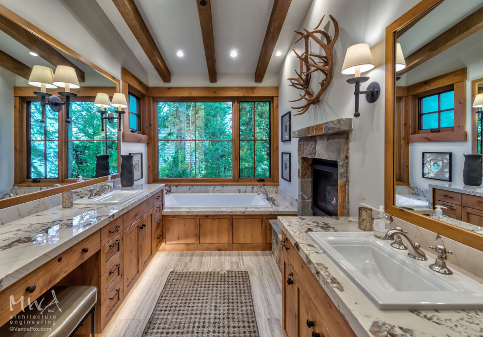 This is an example of a large arts and crafts master bathroom in Other with shaker cabinets, medium wood cabinets, a drop-in tub, white walls, travertine floors, a drop-in sink, multi-coloured floor, grey benchtops, a double vanity and a built-in vanity.
