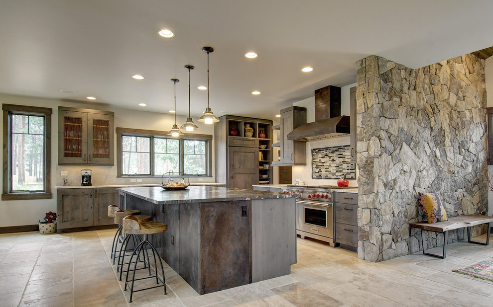 Large mountain style l-shaped travertine floor and beige floor eat-in kitchen photo in Denver with recessed-panel cabinets, dark wood cabinets, stainless steel appliances, an island, granite countertops, multicolored backsplash and matchstick tile backsplash