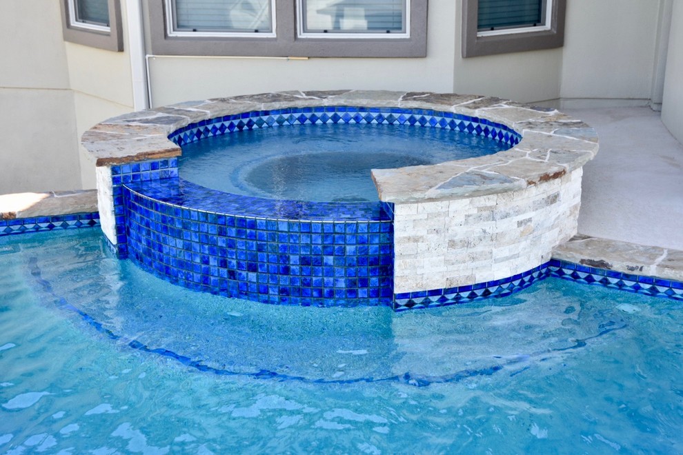 Mid-sized transitional backyard concrete and custom-shaped infinity hot tub photo in Austin