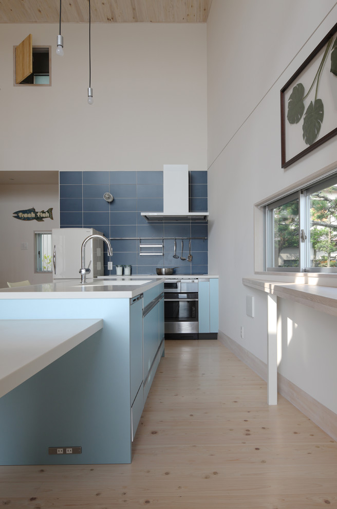 Inspiration for a contemporary galley open plan kitchen in Tokyo Suburbs with an integrated sink, flat-panel cabinets, blue cabinets, solid surface benchtops, blue splashback, porcelain splashback, white appliances, dark hardwood floors, with island and beige floor.
