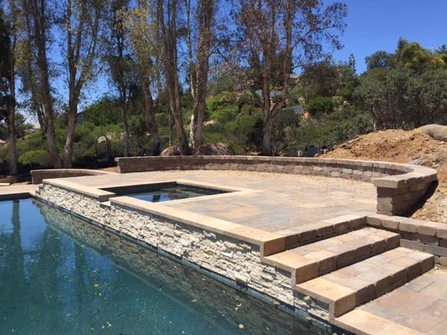 Inspiration for a large traditional backyard rectangular lap pool in San Diego with a hot tub and natural stone pavers.