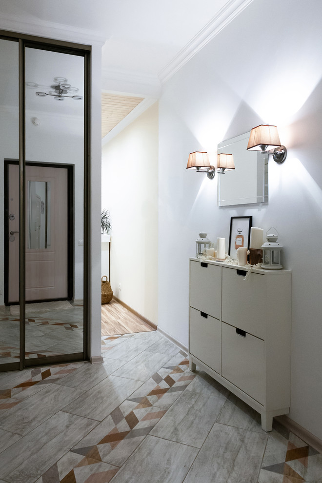 Inspiration for a small scandinavian entry hall in Moscow with white walls, porcelain floors, a single front door, a light wood front door and beige floor.
