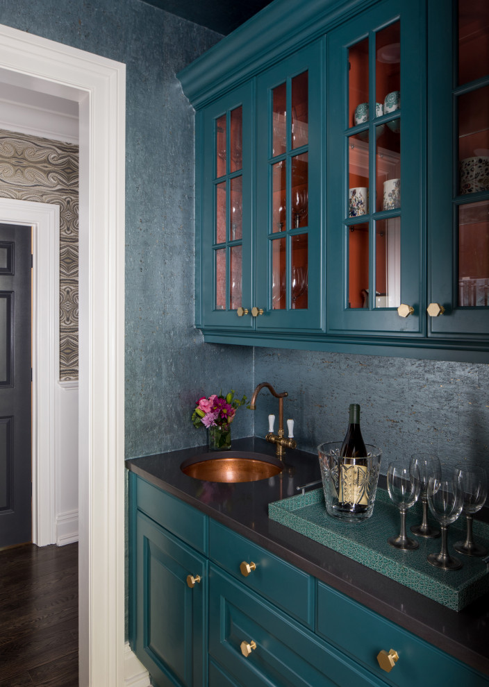 Wet bar - transitional single-wall dark wood floor and brown floor wet bar idea in New York with an undermount sink, raised-panel cabinets, blue cabinets and black countertops