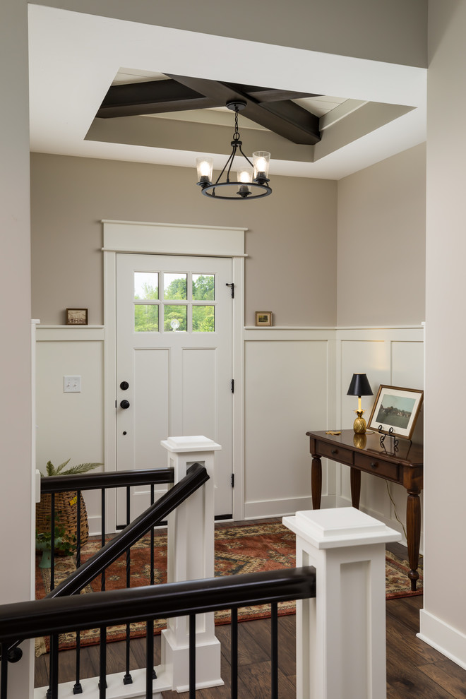 This is an example of a mid-sized country foyer in Grand Rapids with beige walls, a single front door, a white front door, brown floor and laminate floors.