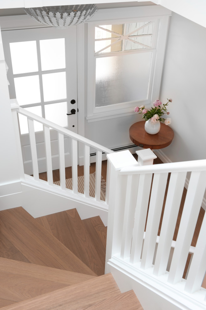 Imagen de escalera en U tradicional de tamaño medio con escalones de madera, contrahuellas de madera pintada, barandilla de madera y panelado