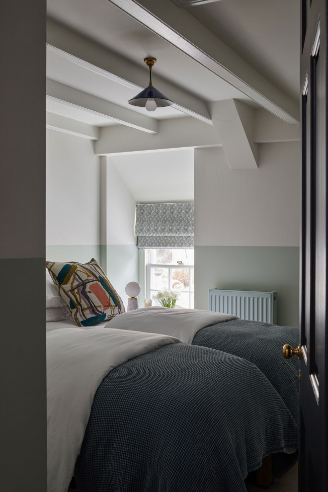This is an example of a medium sized guest bedroom in Other with green walls, carpet, grey floors and a feature wall.