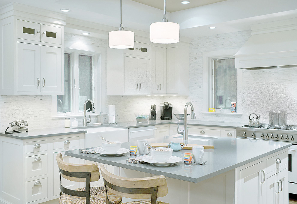 Large transitional u-shaped dark wood floor and brown floor eat-in kitchen photo in New York with a farmhouse sink, shaker cabinets, white cabinets, granite countertops, gray backsplash, ceramic backsplash, stainless steel appliances and an island