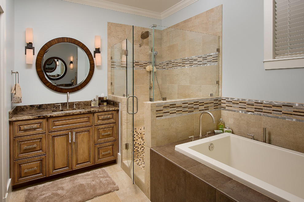 Design ideas for a traditional bathroom in Jacksonville with an undermount sink, raised-panel cabinets, medium wood cabinets, a drop-in tub, an alcove shower, beige tile and brown benchtops.