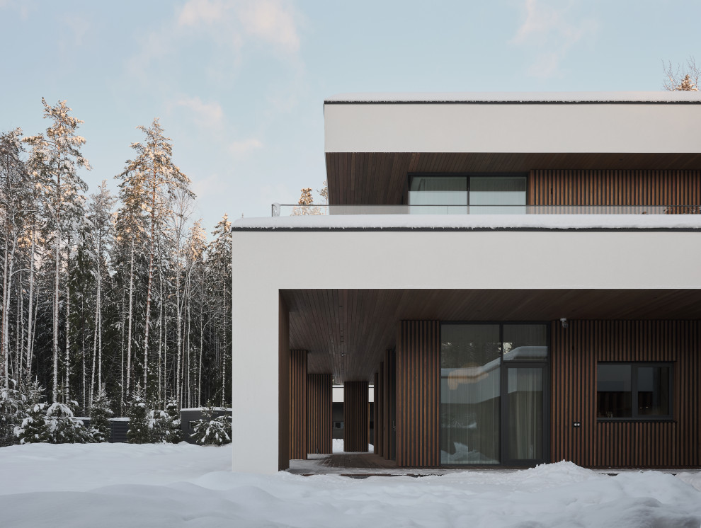 Inspiration for a large contemporary two-storey white house exterior in Saint Petersburg with mixed siding, a flat roof, a mixed roof, a black roof and clapboard siding.