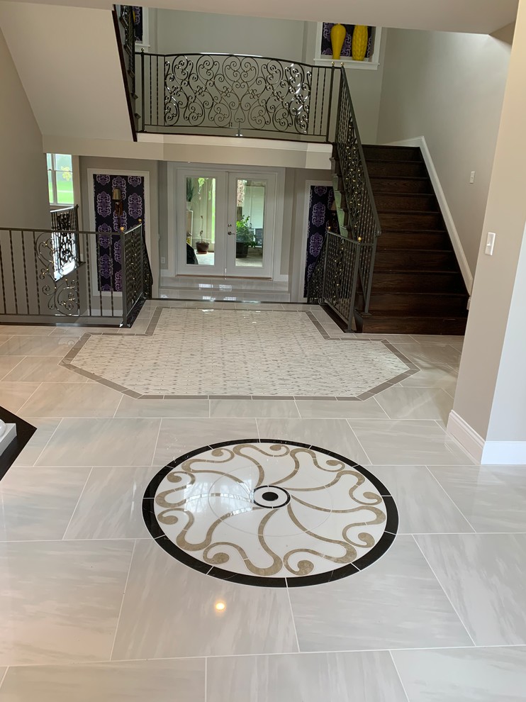 Huge transitional porcelain tile and white floor foyer photo in Cincinnati with gray walls and a dark wood front door