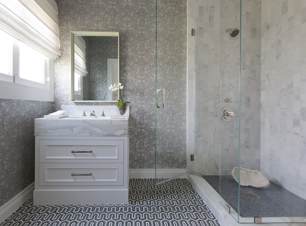 This is an example of a mid-sized traditional 3/4 bathroom in Los Angeles with recessed-panel cabinets, white cabinets, a corner shower, grey walls, mosaic tile floors, an integrated sink and a hinged shower door.