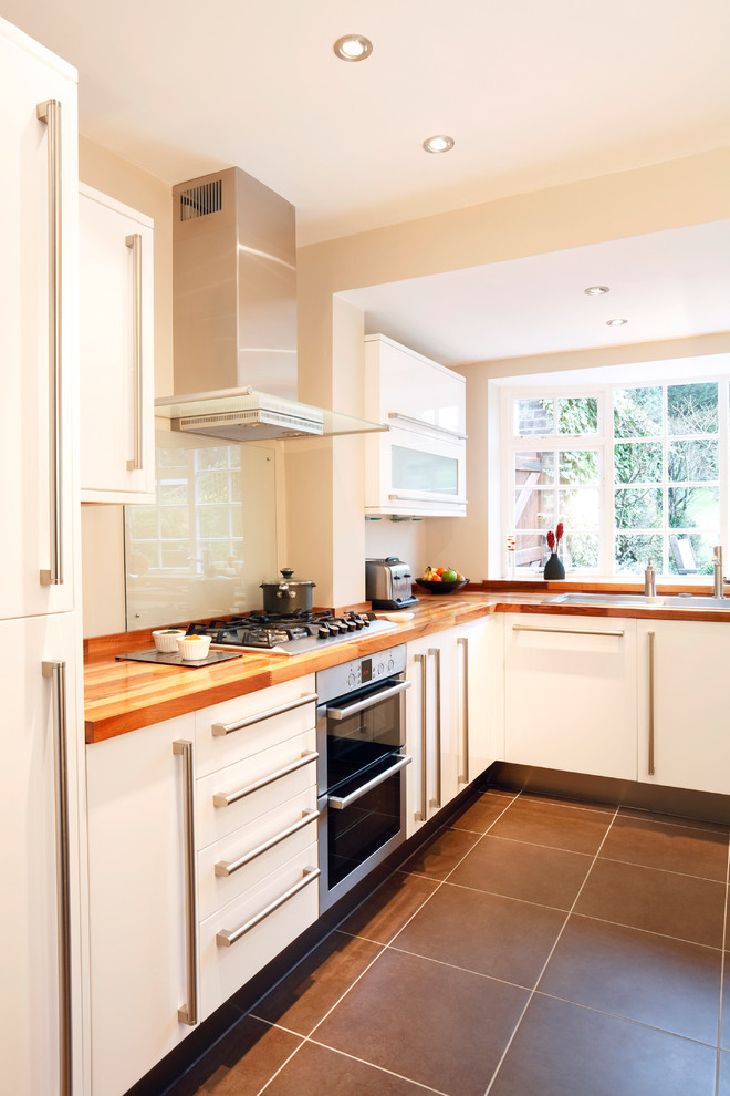 Example of a mid-sized eat-in kitchen design in Minneapolis with an undermount sink, white cabinets, white backsplash and stainless steel appliances