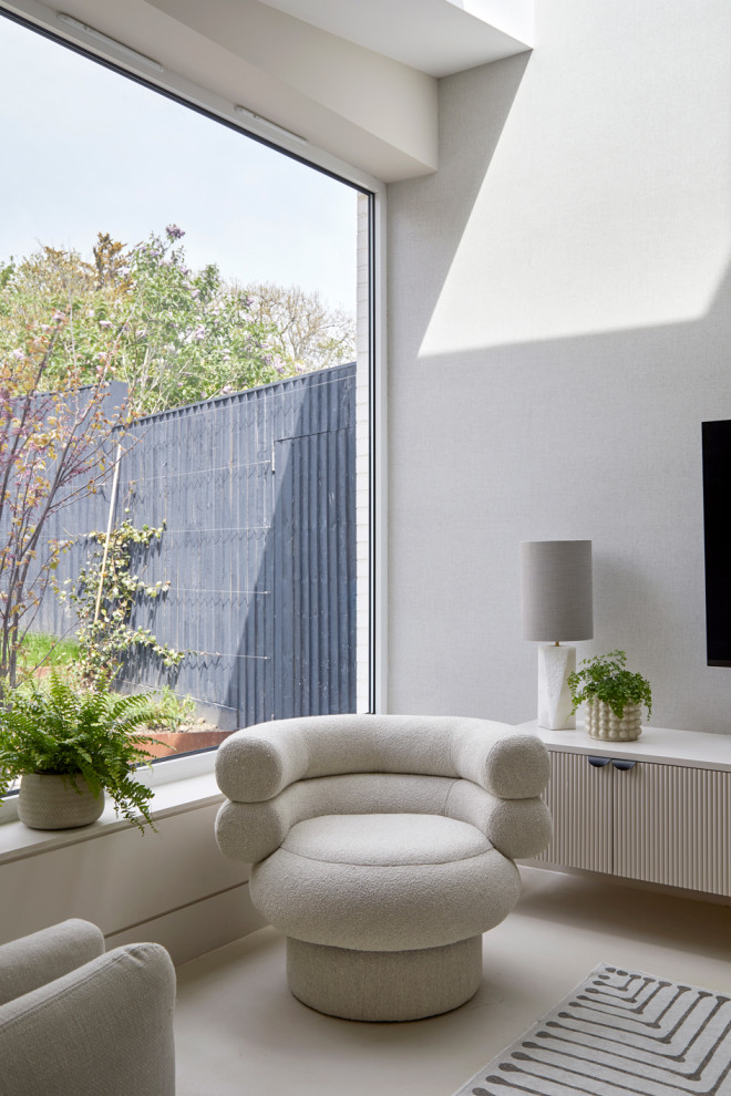 Пример оригинального дизайна: огромная гостиная комната в современном стиле с бетонным полом, телевизором на стене и бежевым полом