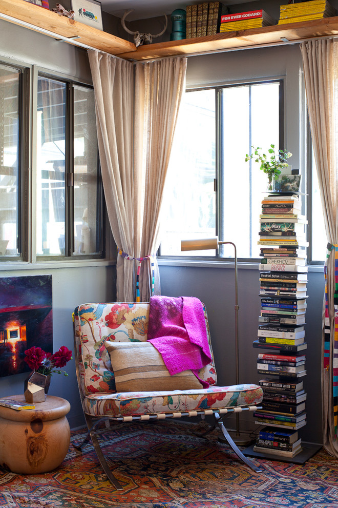 Eclectic living room with grey walls and a library.