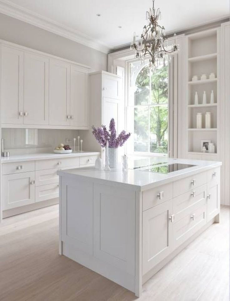 Large traditional l-shaped eat-in kitchen in Columbus with an undermount sink, recessed-panel cabinets, white cabinets, marble benchtops, white splashback, marble splashback, stainless steel appliances, light hardwood floors, with island, brown floor and white benchtop.