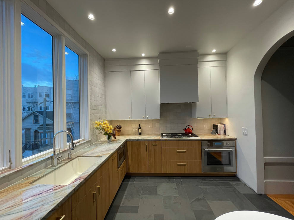 Enclosed kitchen - mid-sized eclectic l-shaped slate floor and gray floor enclosed kitchen idea in Seattle with a single-bowl sink, flat-panel cabinets, light wood cabinets, quartzite countertops, white backsplash, ceramic backsplash, paneled appliances and multicolored countertops