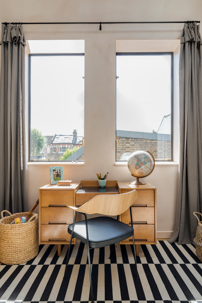 Photo of an urban bedroom in London with pink walls and light hardwood flooring.