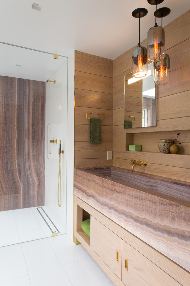 Photo of a mid-sized modern master bathroom in New York with flat-panel cabinets, medium wood cabinets, an alcove shower, a trough sink, white floor, brown tile, multi-coloured tile, stone slab, ceramic floors, onyx benchtops, a hinged shower door and brown benchtops.