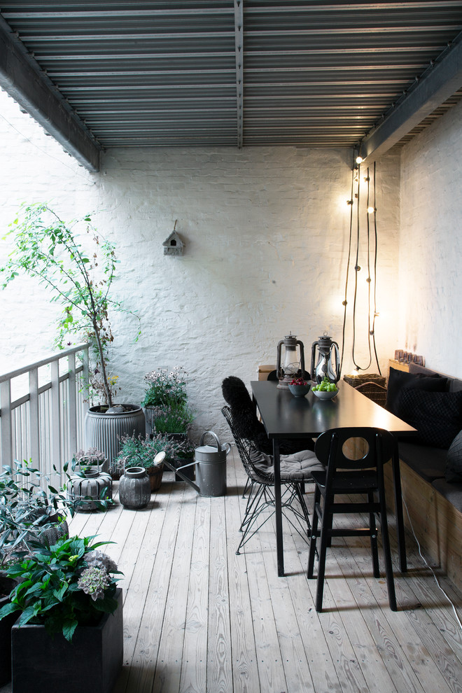 Photo of a mid-sized scandinavian balcony in Copenhagen with a roof extension.