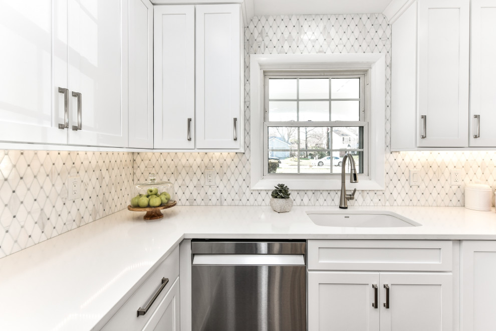 Inspiration for a mid-sized modern u-shaped kitchen in DC Metro with an undermount sink, shaker cabinets, white cabinets, quartzite benchtops, white splashback, marble splashback, stainless steel appliances, vinyl floors, with island, brown floor and white benchtop.