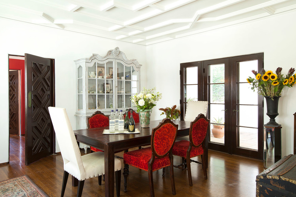 Photo of a mediterranean dining room in Los Angeles with white walls and dark hardwood floors.