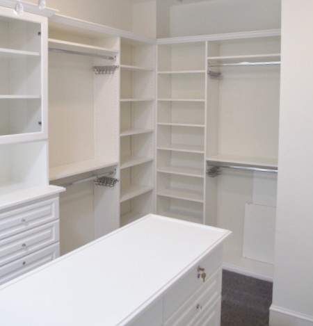 Design ideas for a large traditional gender-neutral walk-in wardrobe in Los Angeles with raised-panel cabinets, white cabinets, carpet and grey floor.