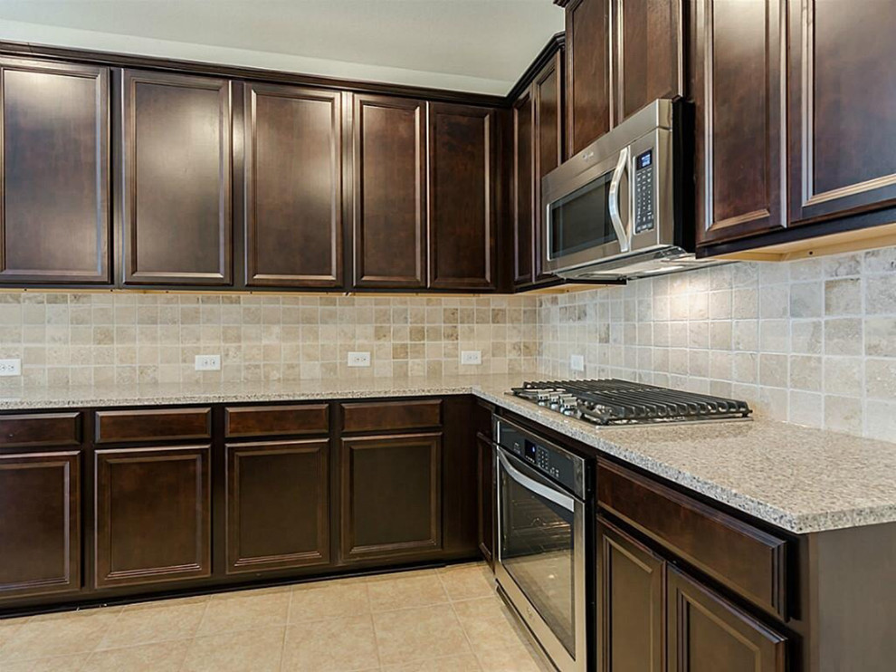 Mid-sized transitional l-shaped dark wood floor open concept kitchen photo with a double-bowl sink, raised-panel cabinets, dark wood cabinets, beige backsplash, stainless steel appliances and an island