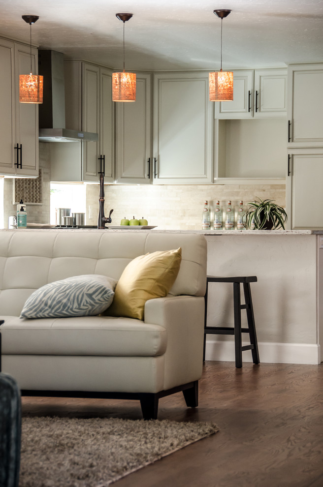 Open concept kitchen - mid-sized transitional u-shaped dark wood floor and brown floor open concept kitchen idea in Denver with granite countertops, beige backsplash, an undermount sink, raised-panel cabinets, white cabinets, a peninsula, ceramic backsplash and stainless steel appliances
