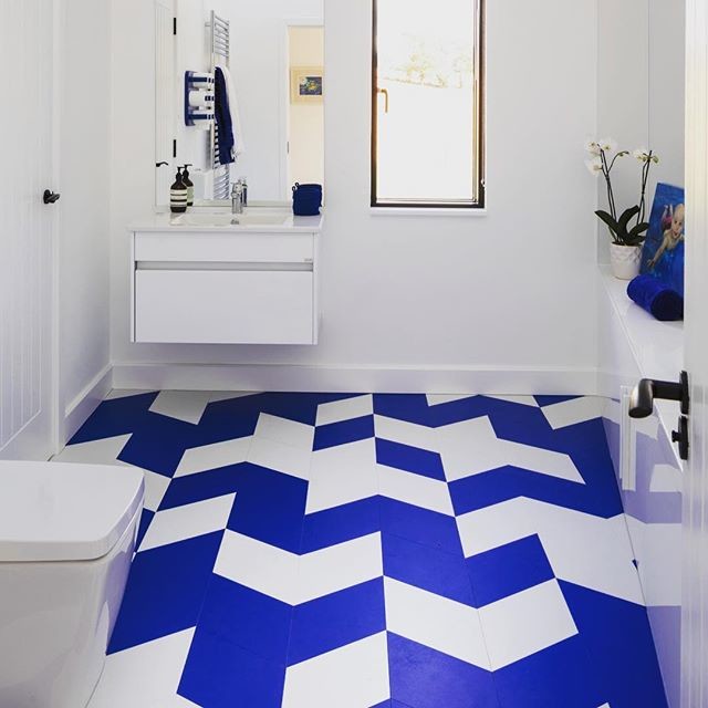 Inspiration for a small 3/4 bathroom with flat-panel cabinets, white cabinets, a bidet, white walls, cement tiles, an undermount sink, engineered quartz benchtops, blue floor and white benchtops.
