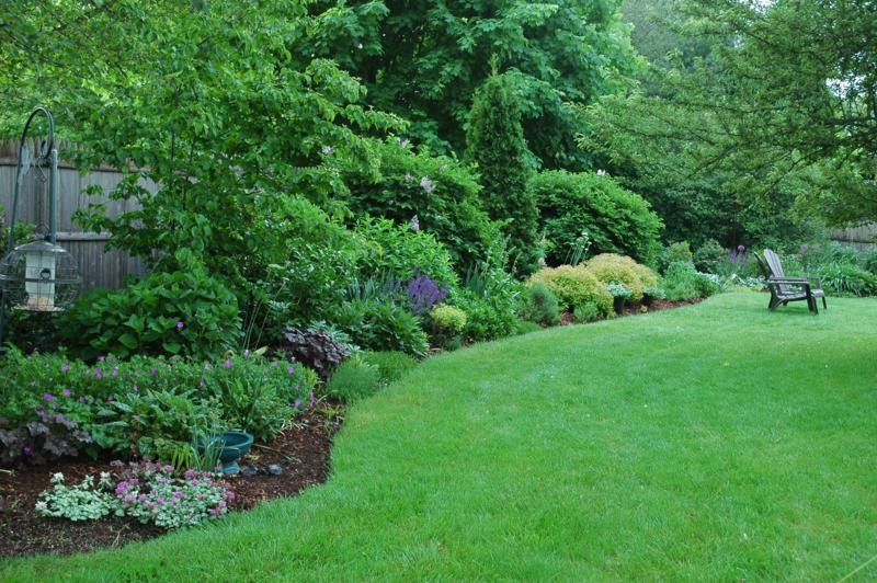 This is an example of a large traditional backyard partial sun formal garden in Providence with a garden path and gravel.